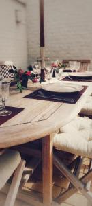 een houten tafel met borden en wijnglazen erop bij Huize Andries in Brugge