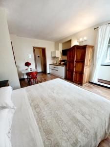 a bedroom with a large white bed and a kitchen at Locanda del Sale in Genoa
