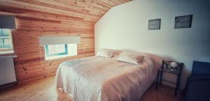 een slaapkamer met een bed in een kamer met houten wanden bij Huize Andries in Brugge