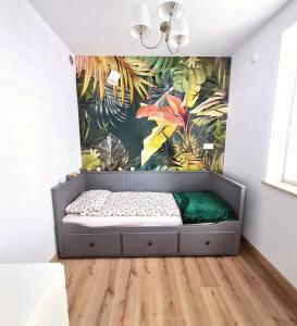 ein Schlafzimmer mit einem Bett in einem Zimmer mit Wandbild in der Unterkunft Apartament Sosnowa in Puławy