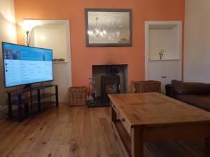 un soggiorno con TV a schermo piatto e tavolino da caffè di Riverside Cottage City Centre a Inverness