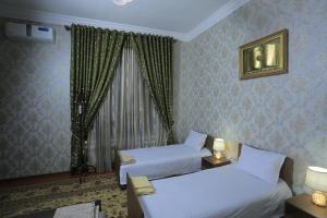 a hotel room with two beds and a window at Royal lux Guest House in Samarkand