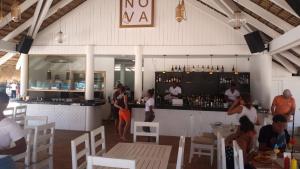 um grupo de pessoas em pé em torno de um bar em um restaurante em Rolando share apart em Punta Cana