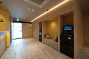 um corredor de escritório com um sofá e uma televisão nele em Hotel Sun em Takasaki