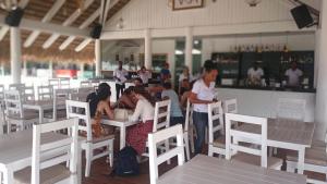 a group of people sitting at tables in a restaurant at Rolando share apart in Punta Cana +84 photos