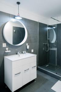 un bagno con lavandino e doccia con specchio di Mavie Apartment Boutique a Bucarest Altre 33 foto