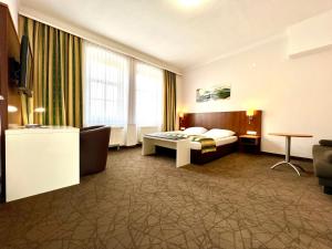 um quarto de hotel com uma cama e um sofá em Residenz Royal em Gmünd