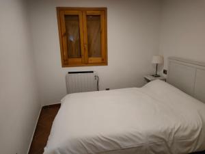 a bedroom with a white bed and a cabinet at Apartment in Llavorsi in the heart of the Catalan Pyrenees in Llavorsí