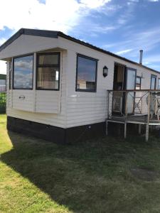 a white tiny house sitting on top of a yard at Melody Brooks Caravan Park in Portknockie