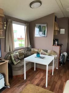 a living room with a white table and a couch at Melody Brooks Caravan Park in Portknockie