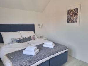 una camera da letto con un letto e asciugamani di Arboretum Apartments Kórnik a Kórnik