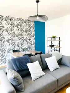 - un salon avec un canapé et un mur bleu dans l'établissement Appartement A Deux Pas situé en Hyper Centre Ville, à Rouen