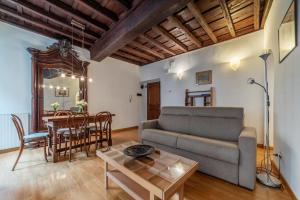 a living room with a couch and a table at Tucked away and quiet by Piazza Navona - FromHometoRome in Rome
