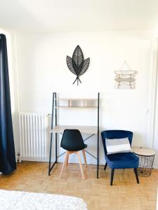 Cette chambre dispose d'un bureau, d'une chaise et d'une plante sur le mur. dans l'établissement Appartement A Deux Pas situé en Hyper Centre Ville, à Rouen