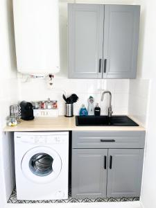 a kitchen with a washing machine and a sink at Appartement A Deux Pas situé en Hyper Centre Ville in Rouen