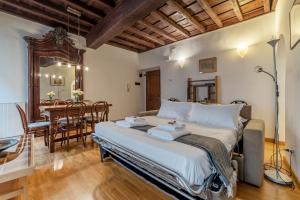 a bedroom with a large bed and a dining room at Tucked away and quiet by Piazza Navona - FromHometoRome in Rome