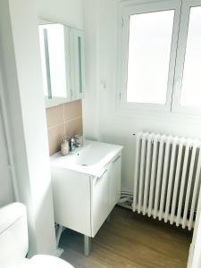 Appartement A Deux Pas situé en Hyper Centre Ville في رووين: حمام ابيض مع مغسلة وراديتور