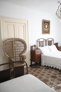 a bedroom with a bed and a chair and a table at Casa Aulivo, dimora storica con vista in Caiazzo