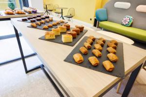 a table with several trays of bread and pastries at Inn Boutique León in León