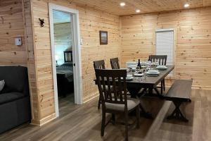 a dining room with a table and chairs in a cabin at Chalet le Huard directement au bord du lac in Saint Zenon