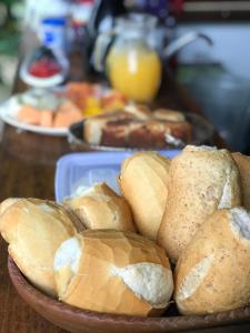 um prato de pães numa mesa de madeira em Pousada kaz'oca em Icaraí