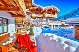 a house in the snow with a red blanket of snow at Alpendorf Anno Dazumal in Tux