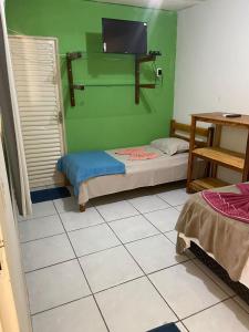 a room with two beds and a flat screen tv at Estância Cyclo das Águas in Nobres