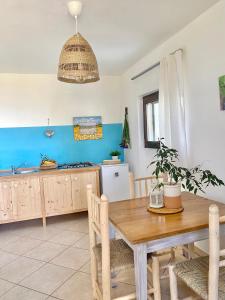 una cucina con tavolo in legno e una sala da pranzo di La Dimora di Ulisse a Santa Cesarea Terme