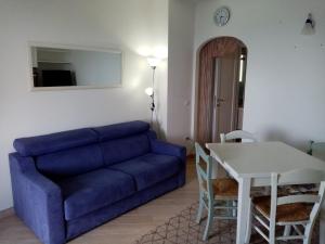 sala de estar con sofá azul y mesa en Greta, en Castelsardo