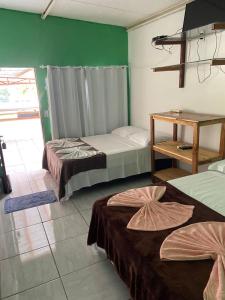 two beds in a room with green walls at Estância Cyclo das Águas in Nobres