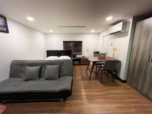 a living room with a couch and a bed and a table at Coconut Garden Đồng Tháp in Ấp Bình Hiệp