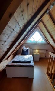 a bedroom with a bed in the attic at Ferienhaus Luetje-Huuske in Krummhörn