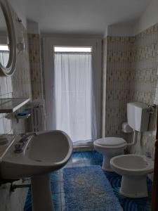 a bathroom with a sink and a toilet and a window at casa vacanze morà 2 in Roccaforte Mondovì