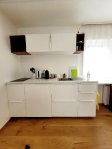 a kitchen with white cabinets and a sink at Apartment Sonnenschein in Dornbirn