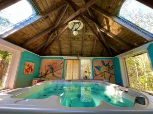 een groot bad in een kamer met ramen bij Driftwood Country Apartment in Skibbereen