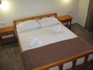 a bed with two pillows and towels on it at George house in Theologos