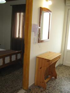 una camera con specchio, tavolo e letto di George house a Theológos