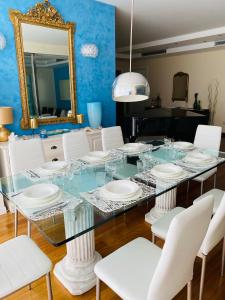 ボルディゲーラにあるVilla Monetのダイニングルーム(ガラステーブル、白い椅子付)