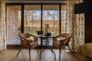 a room with a table and chairs and a balcony at PRZYTULIA in Olsztyn