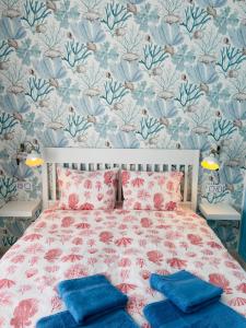 a bedroom with a bed with a floral wallpaper at Blue House Mallorca in Ses Salines