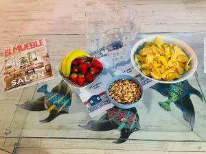 a table with two bowls of fruit and a bowl of nuts at Blue House Mallorca in Ses Salines