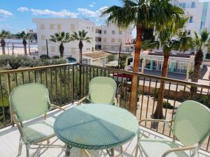 a table and chairs on a balcony with palm trees at Blue House Mallorca in Ses Salines