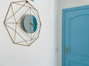 a mirror hanging on a wall next to a blue door at Blue House Mallorca in Ses Salines