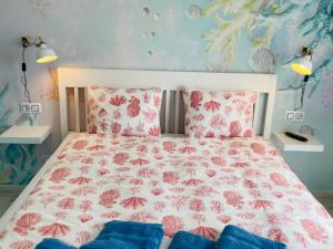 a bedroom with a bed with pink flowers on it at Blue House Mallorca in Ses Salines