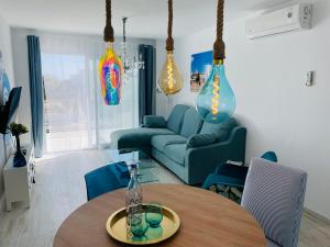 a living room with a table and a blue couch at Blue House Mallorca in Ses Salines