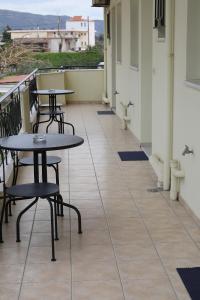 Un balcón con mesas y sillas en un edificio en Flo's Apartments, en Mesolongi