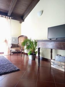 a living room with a table with a flat screen tv at casa vacanze morà 2 in Roccaforte Mondovì