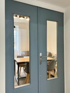 a blue door with a table and chairs in a room at Chai Merlot in Saint-Cyprien