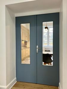 a blue door with two windows in a kitchen at Chai Merlot in Saint-Cyprien