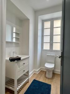 a bathroom with a toilet and a sink and a window at Chai Merlot in Saint-Cyprien